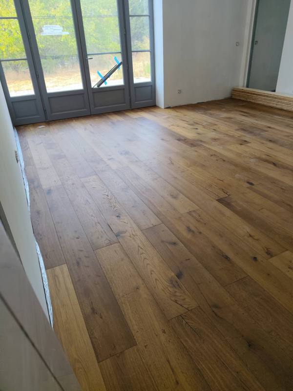 Parquet chêne massif devant une porte-fenêtre