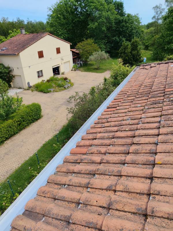 Rive de toit en zinc le long d'une couverture en tuiles